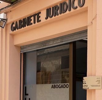 Letrero en el escaparate que dice “Gabinete Jurídico” encima de una puerta de vidrio marcada como “Abogado”