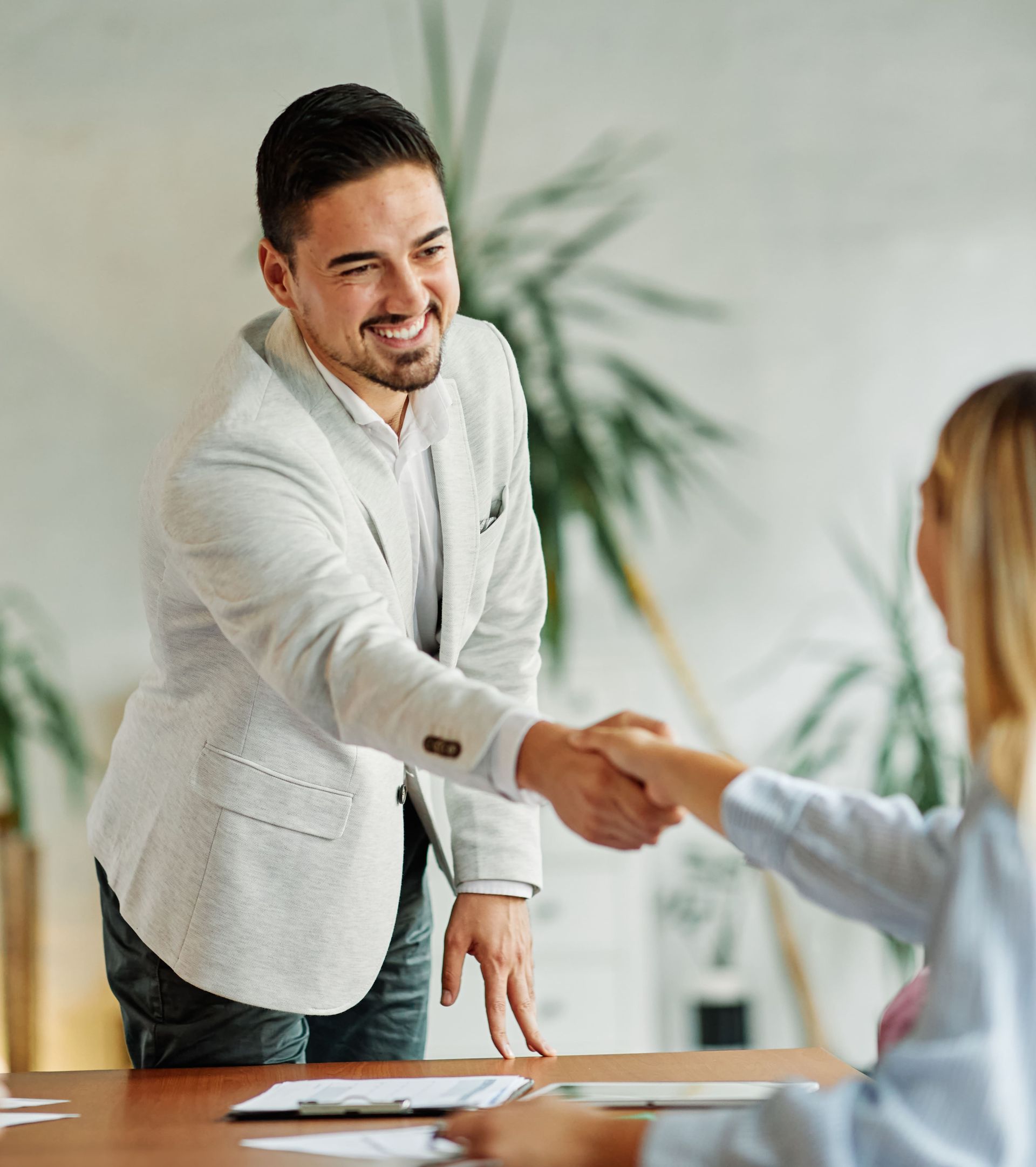 Fröhlicher Mann schüttelt seiner Schuldnerberaterin die Hand
