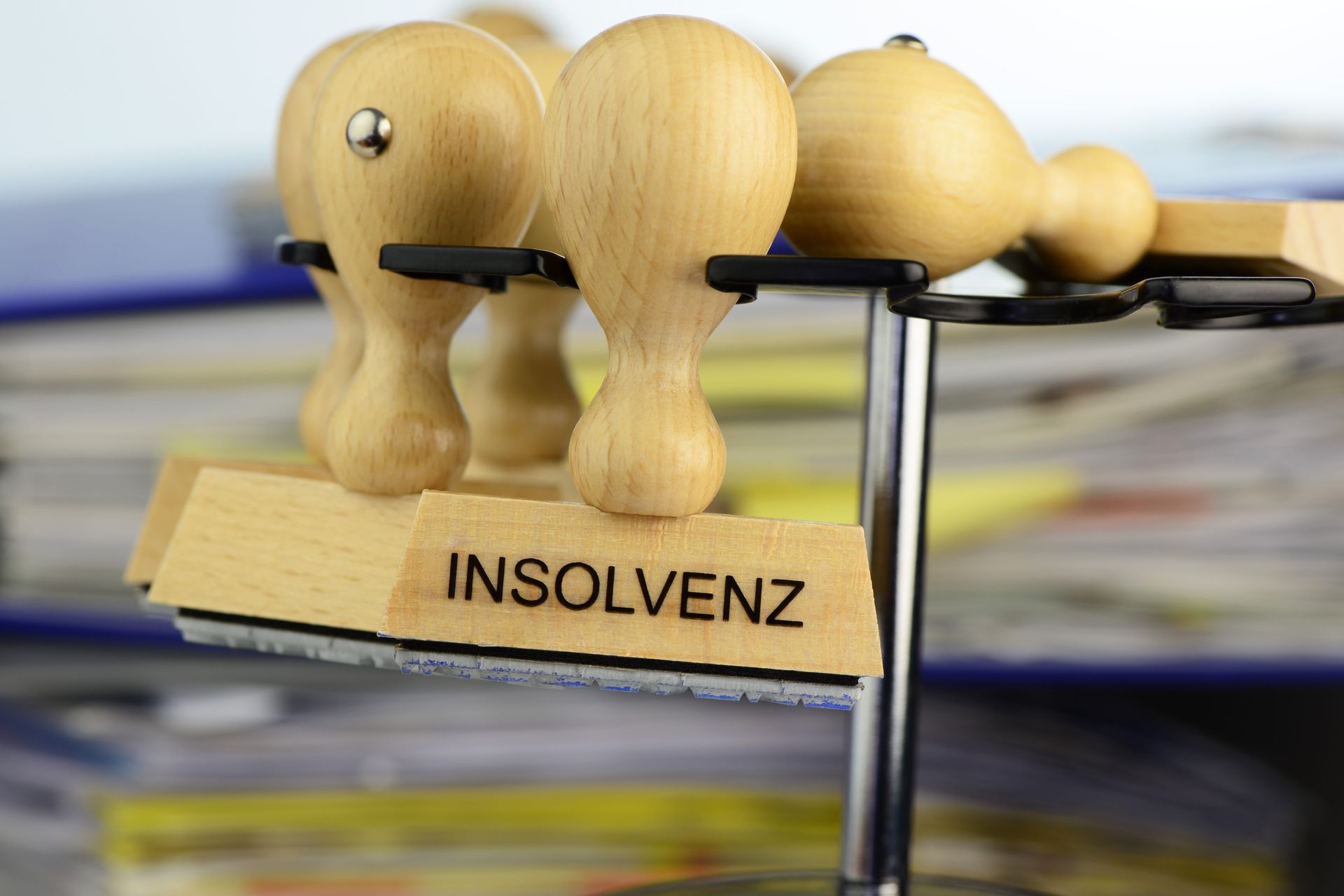 Holzstempel mit Insolvenz-Aufdruck hängt auf einem Ständer