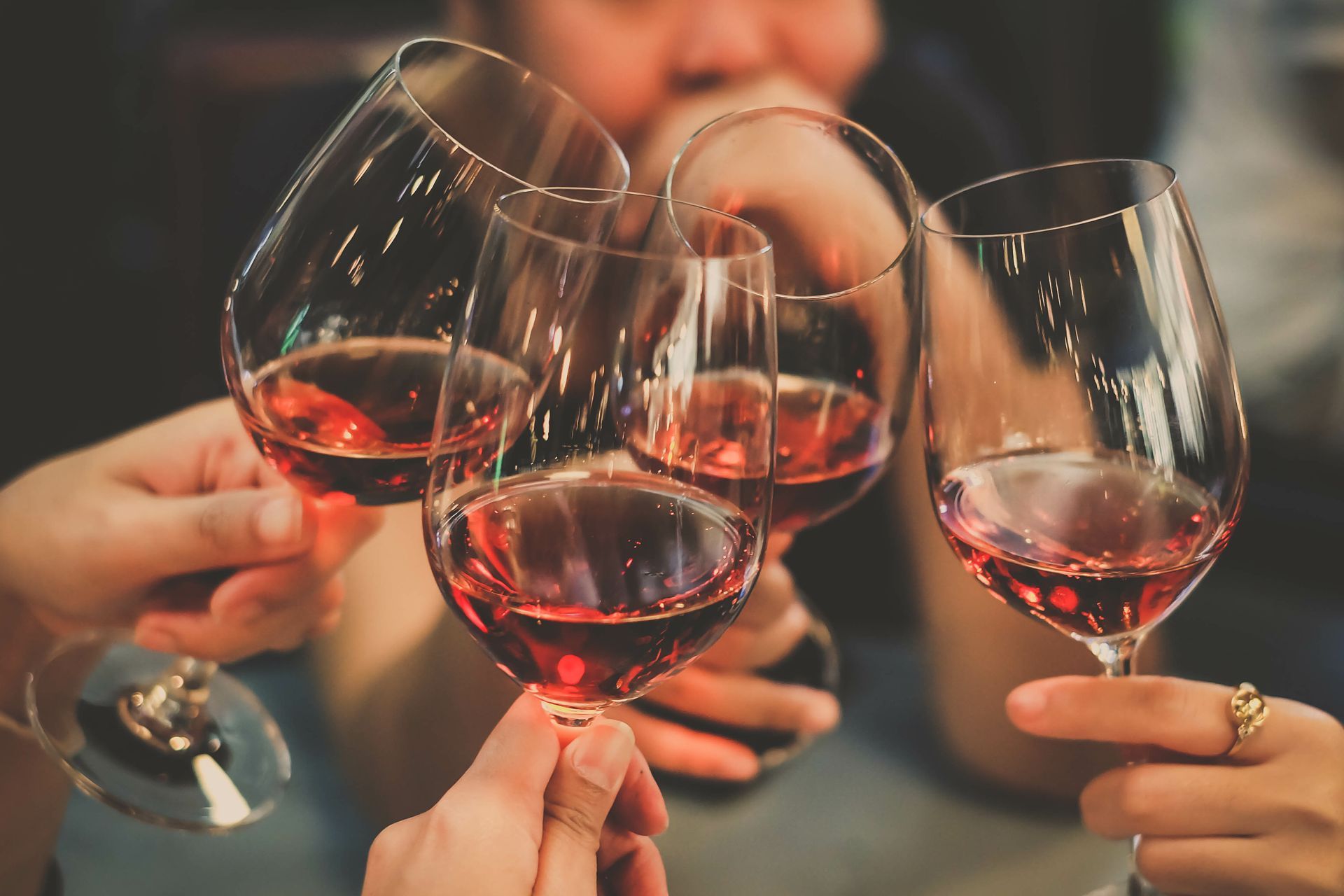 Des personnes trinquent avec des verres de vin rouge