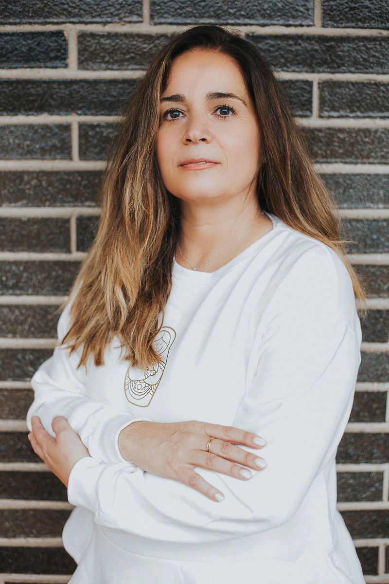 Una mujer está parada en un campo con los brazos extendidos.