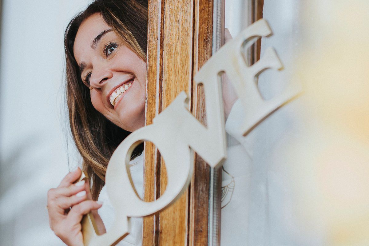 Una mujer está sentada en un sofá abrazándose a sí misma.