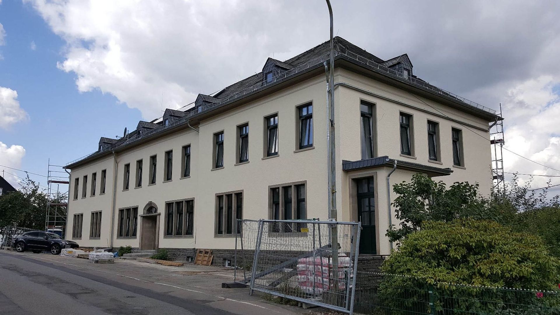 Es wird ein großes weißes Gebäude mit einem Zaun darum gebaut.