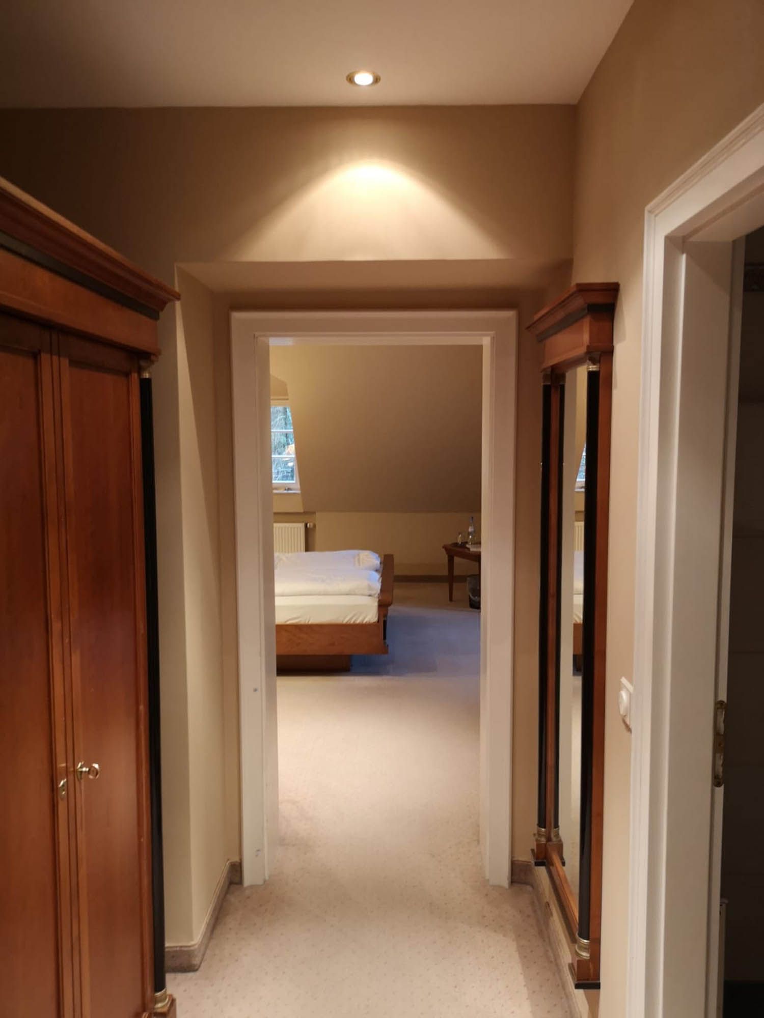 Ein Flur, der zu einem Schlafzimmer mit einem Bett führt