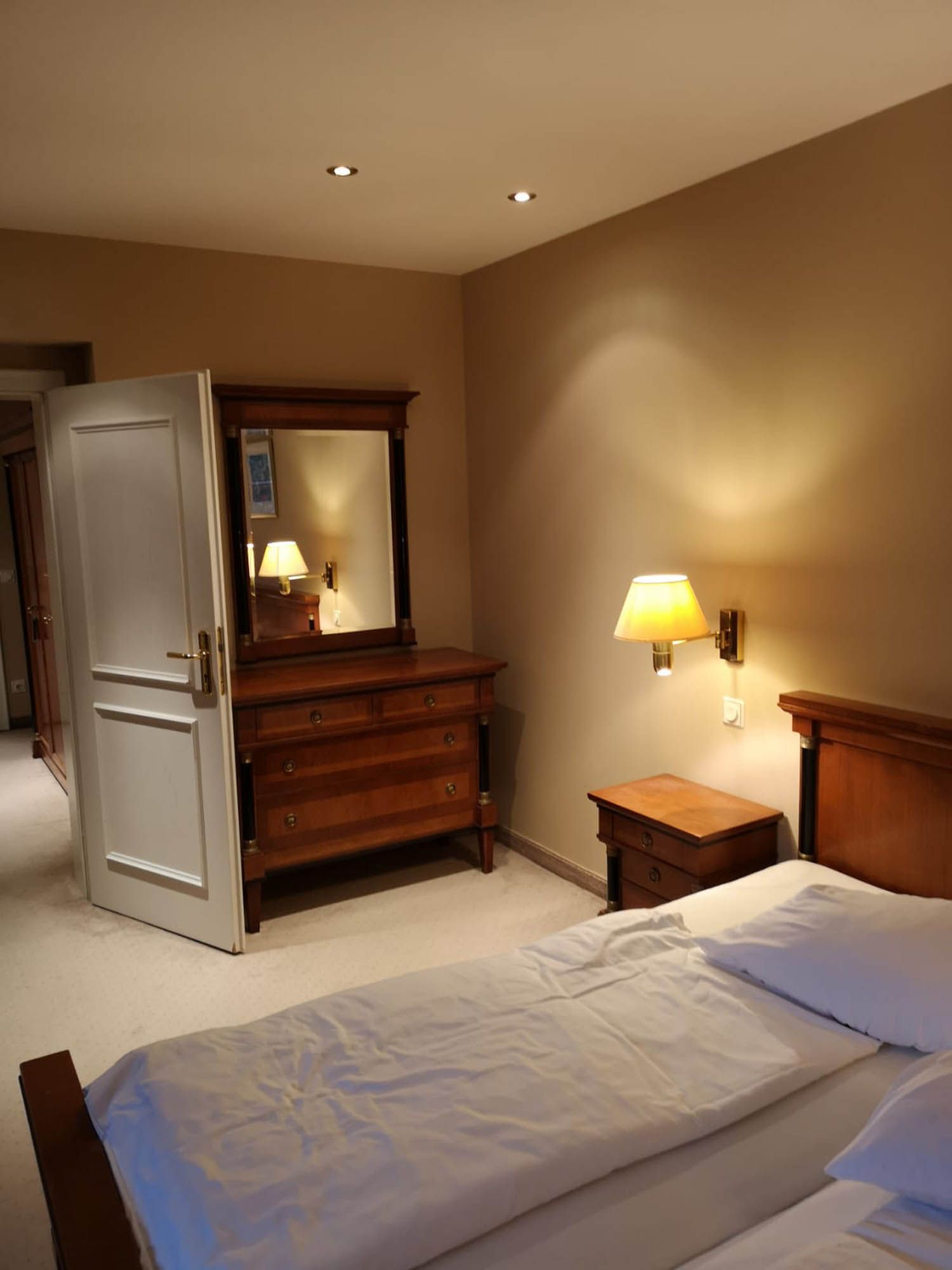 Ein Schlafzimmer mit zwei Betten, einer Kommode und einem Spiegel