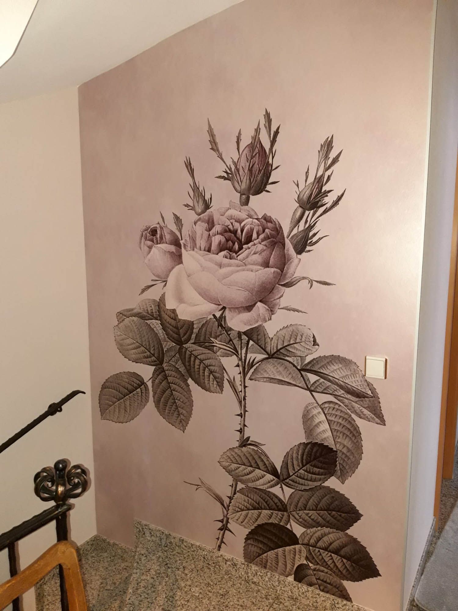 Eine Wand mit einem Gemälde einer Rose darauf