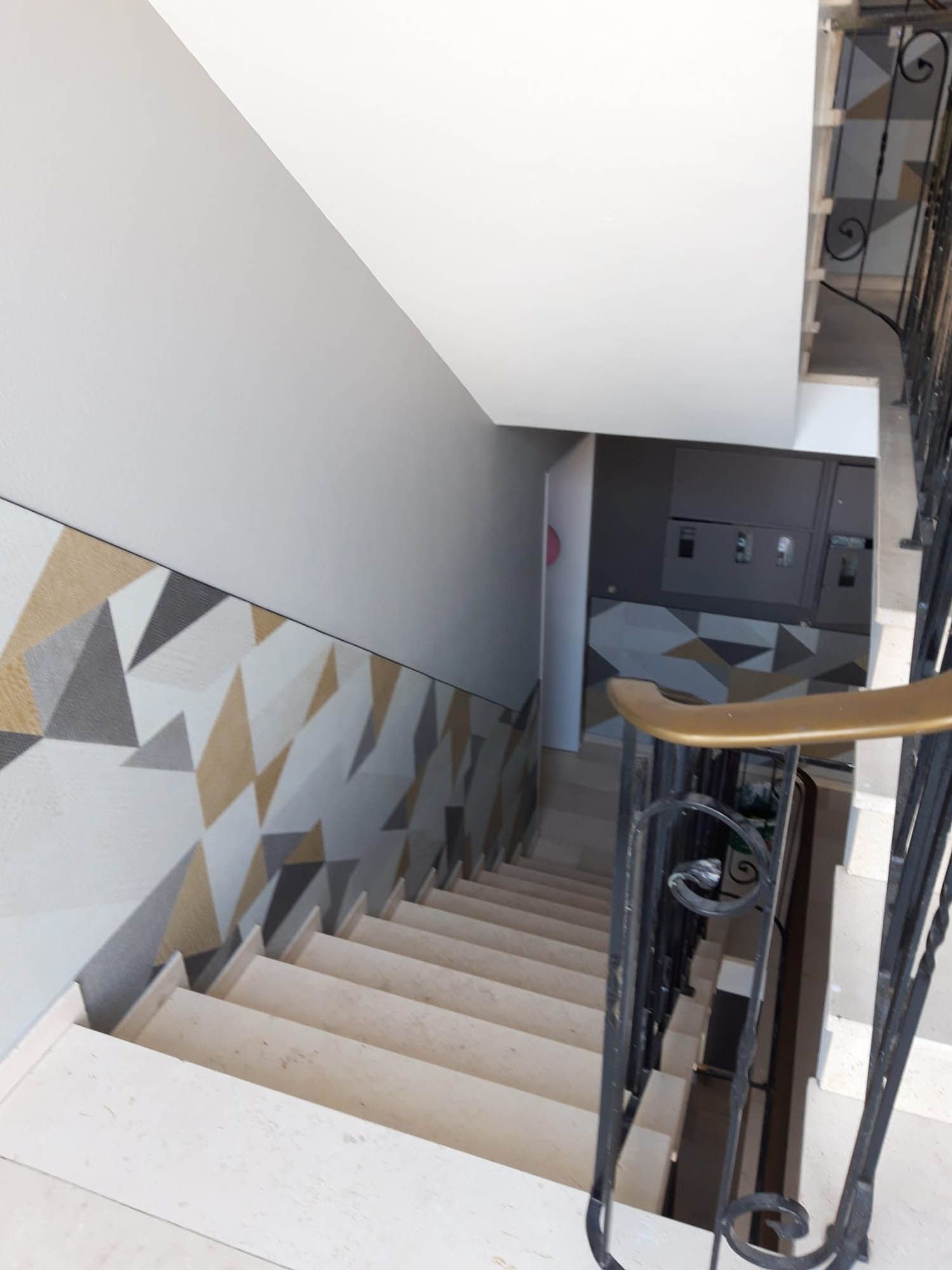 Eine Treppe mit schmiedeeisernem Geländer, die in den zweiten Stock führt