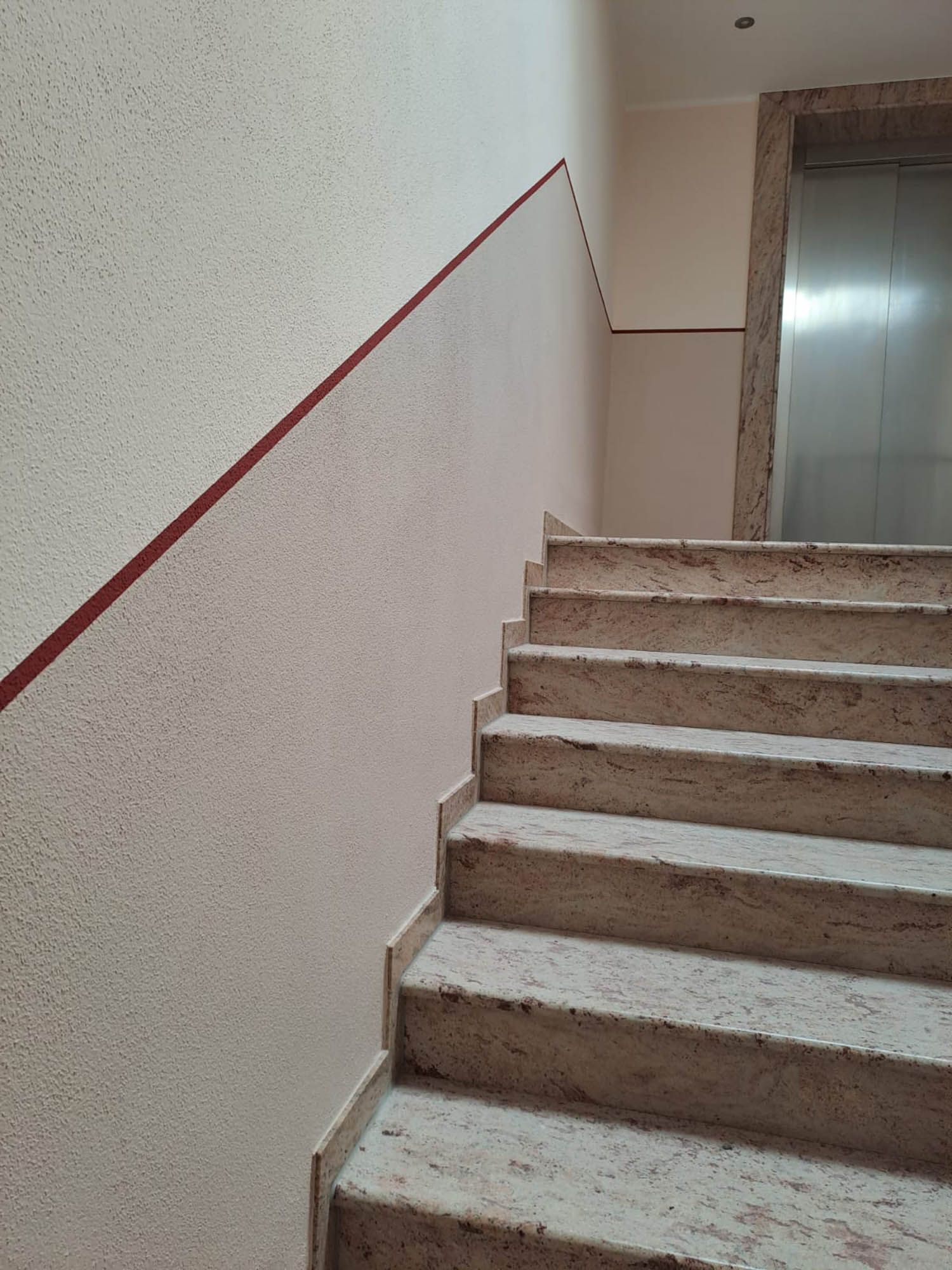 Eine Treppe, die zu einem Aufzug in einem Gebäude führt.