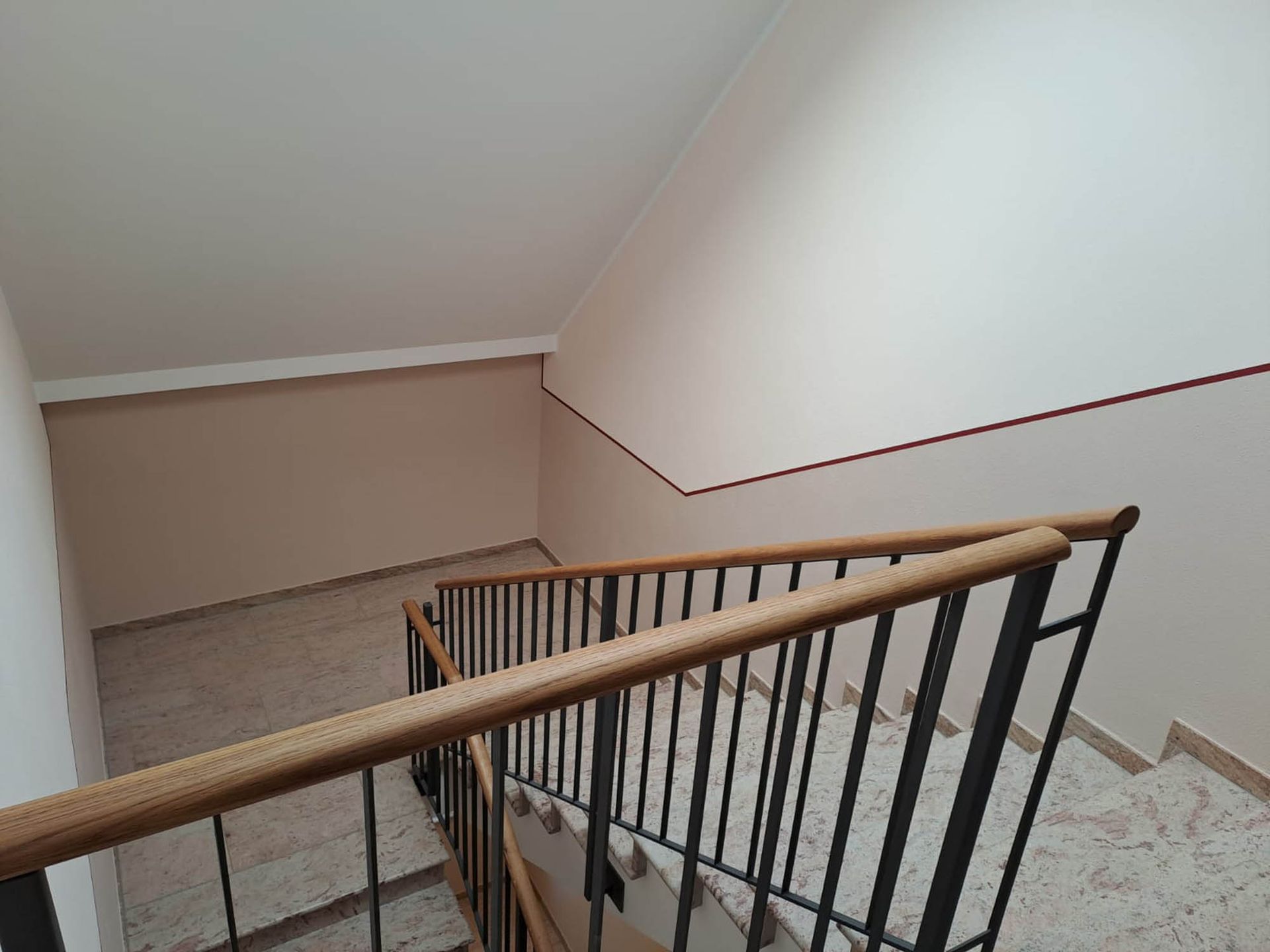 Eine Treppe mit einem Holzhandlauf und einem Metallgeländer in einem Gebäude.