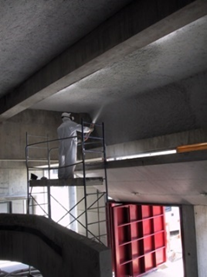 Home effectuant la projection de flocage pour un plafond