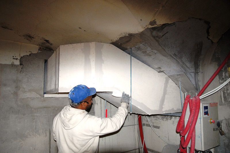 Installation d'équipements de désenfumage par un ouvrier au centre hospitalier Le Vinatier à Bron