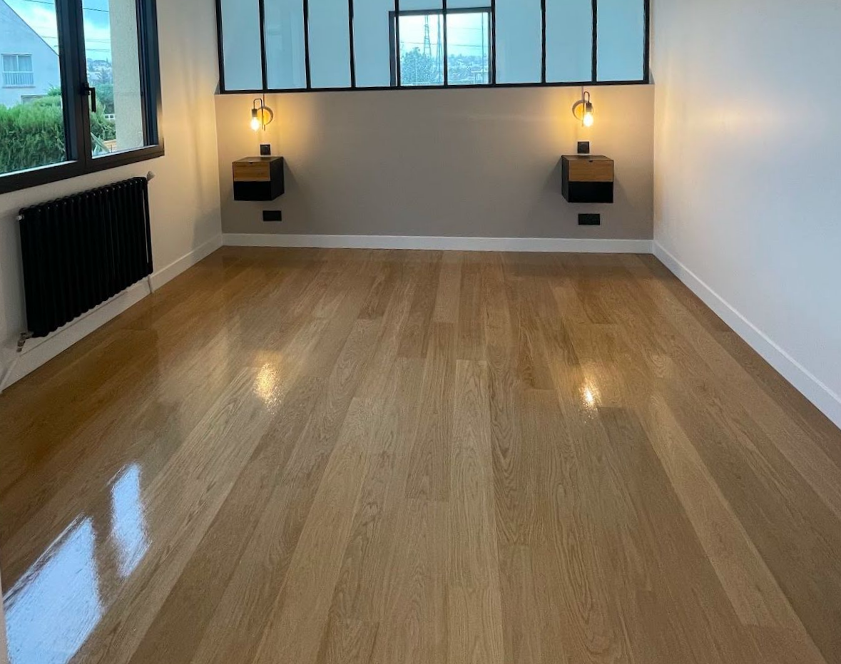 Chambre vide avec parquet poli, murs neutres, fenêtres et tables de chevet flottantes avec lumières.