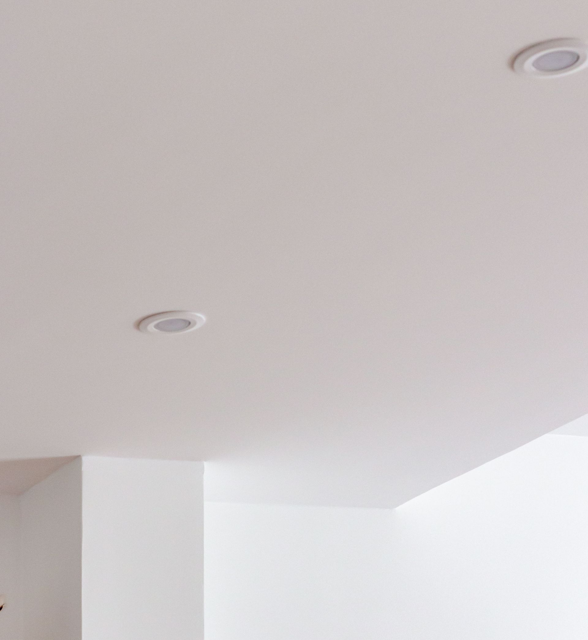 Plafond blanc avec deux spots encastrés.