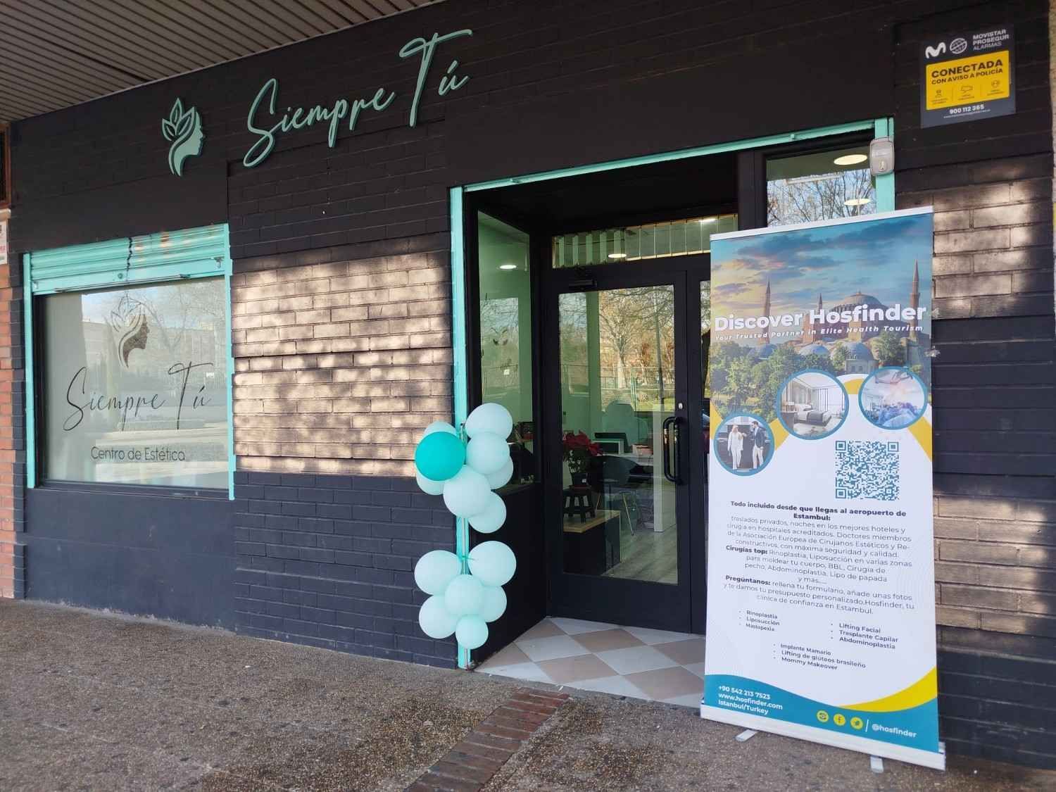 Productos de spa, flores y vegetación dispuestos sobre una superficie de color azul claro.