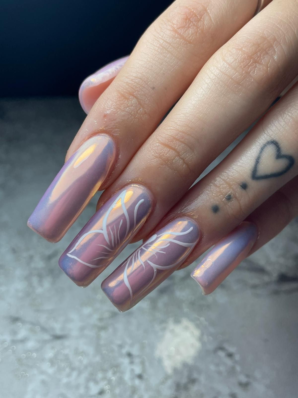 Tres frascos de esmalte de uñas: verde azulado, menta y magenta sobre fondo diagonal rosa y verde.