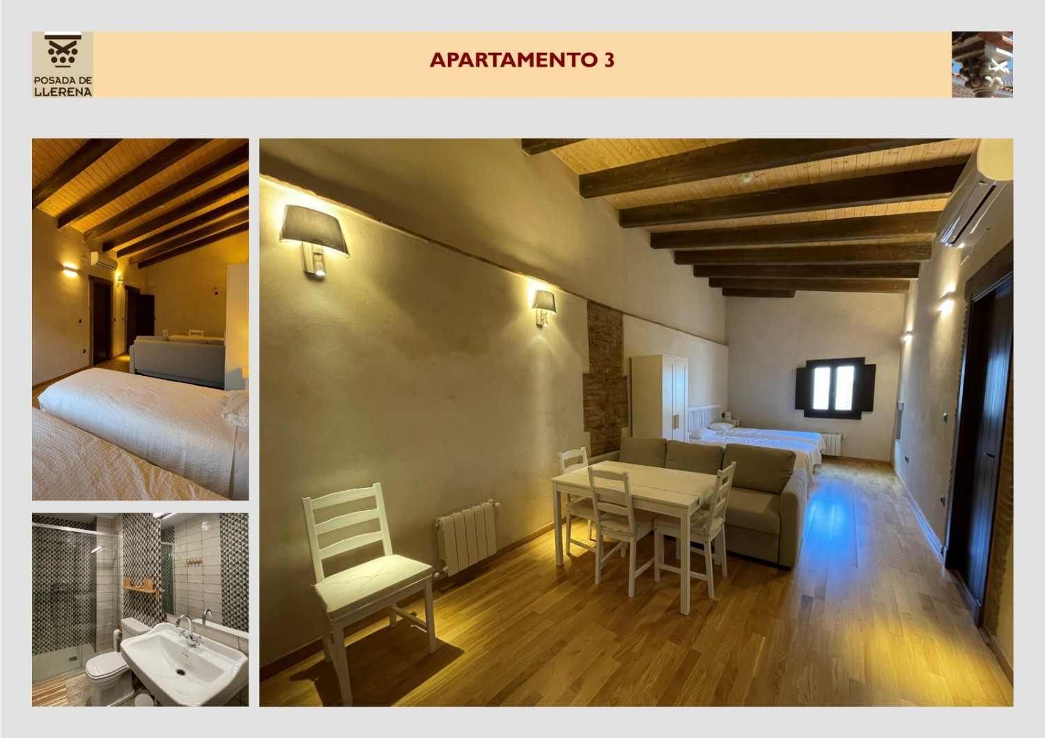 Acogedor comedor-sala de estar en un apartamento, con vigas de madera, muebles blancos y apliques de pared