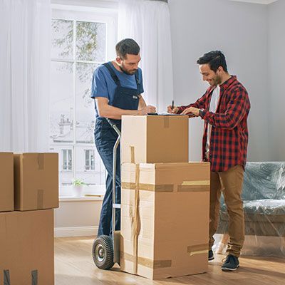 Individu signant un devis d'un déménageur en tenue.