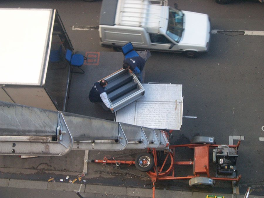 Professionnel récupérant un objet lourd sur un monte-charge.