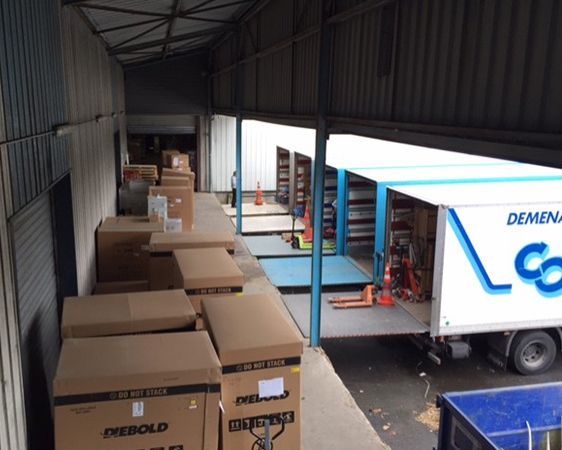 Entrepot avec plusieurs cartons prêt à être transportés par des camions.