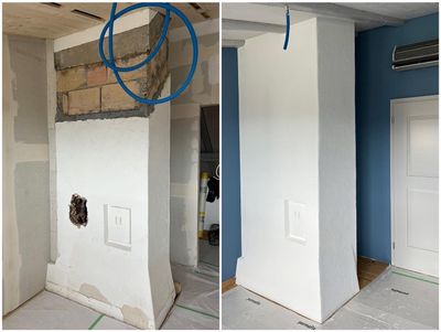 Eine Hand, die eine Farbrolle mit gelbem Griff hält, trägt dicke weisse Farbe auf eine hellgrüne Wand auf.