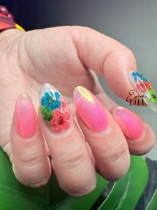 Un primer plano de la mano de una mujer con uñas verdes y uñas con estampado de leopardo.