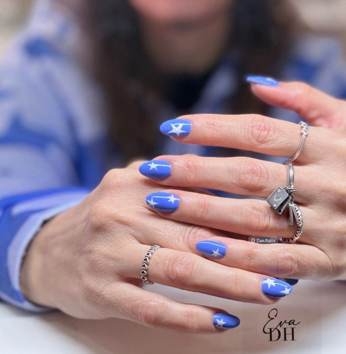 Un primer plano de la mano de una mujer con uñas moradas.