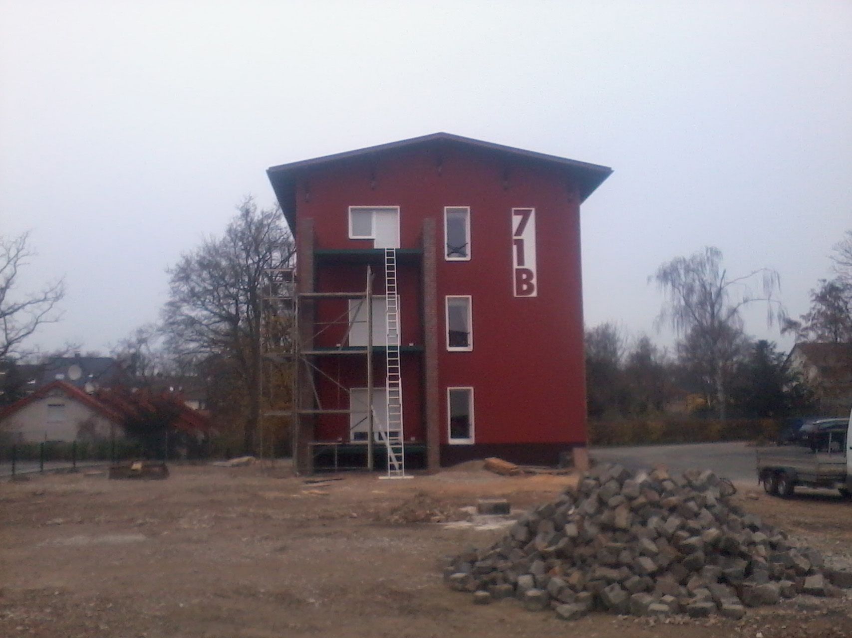 Rotes Mehrfamilienhaus mit Gerüst.