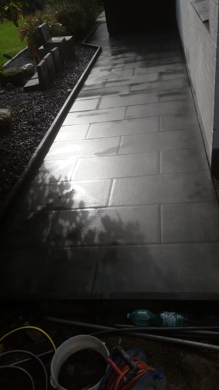 Schwarz gefliester Gehweg, der zu einem Haus führt.