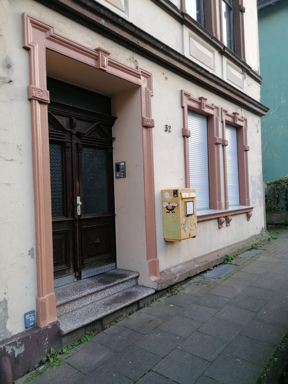 Ein Gebäude mit einem gelben Briefkasten davor