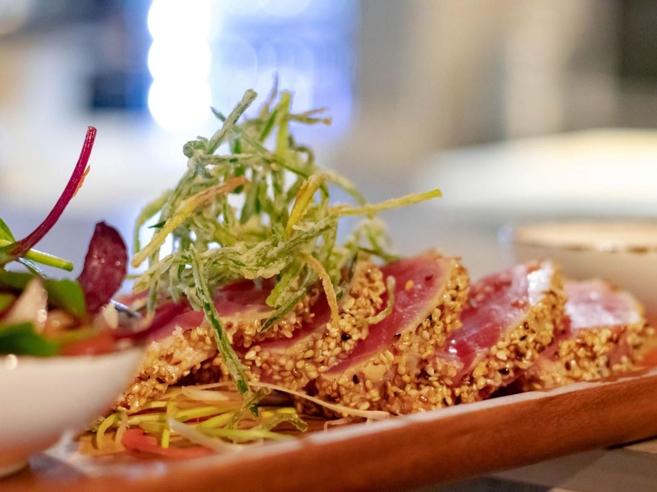 A close up of a plate of food with meat and vegetables on a table.