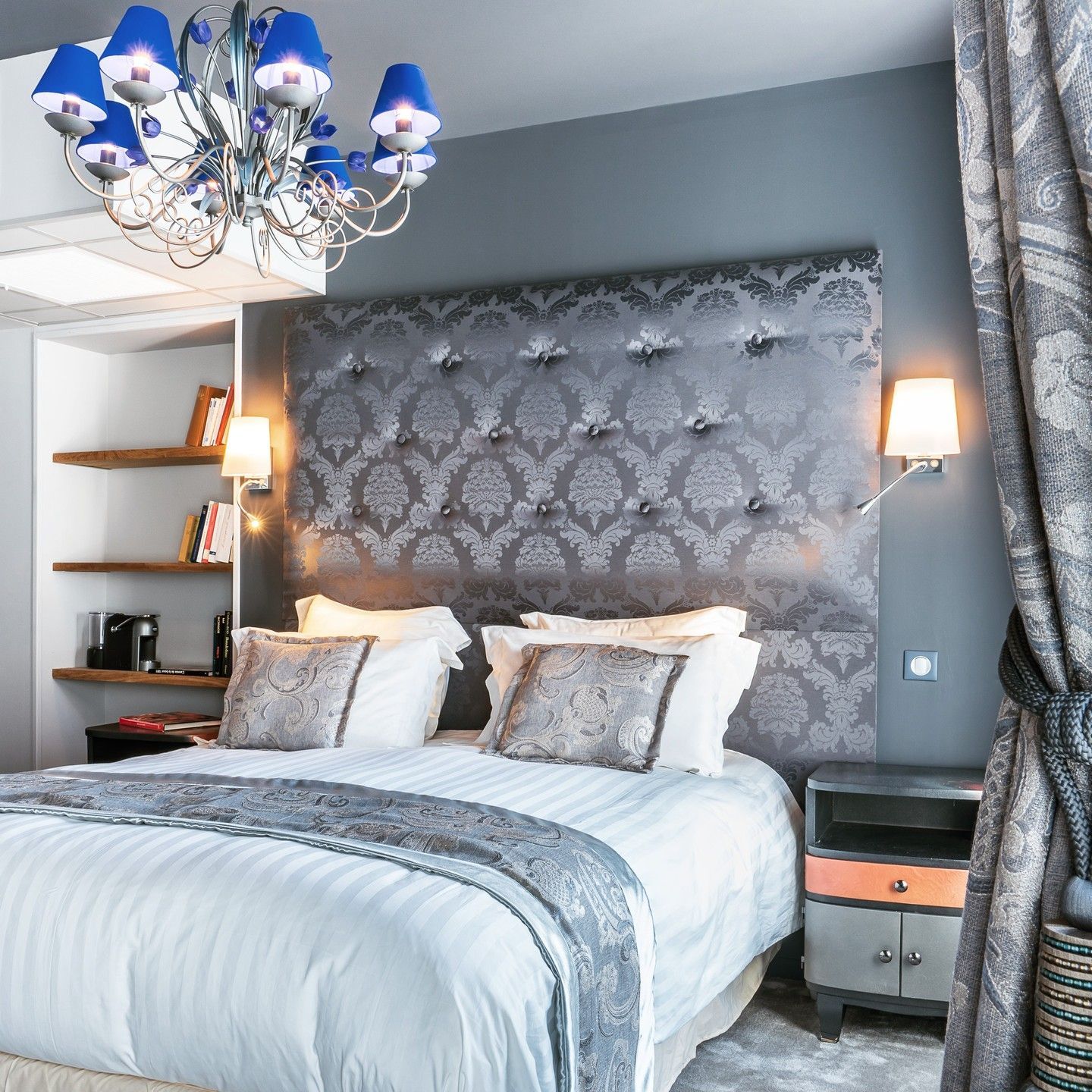 Lit queen size, tête de lit grise, lustre bleu