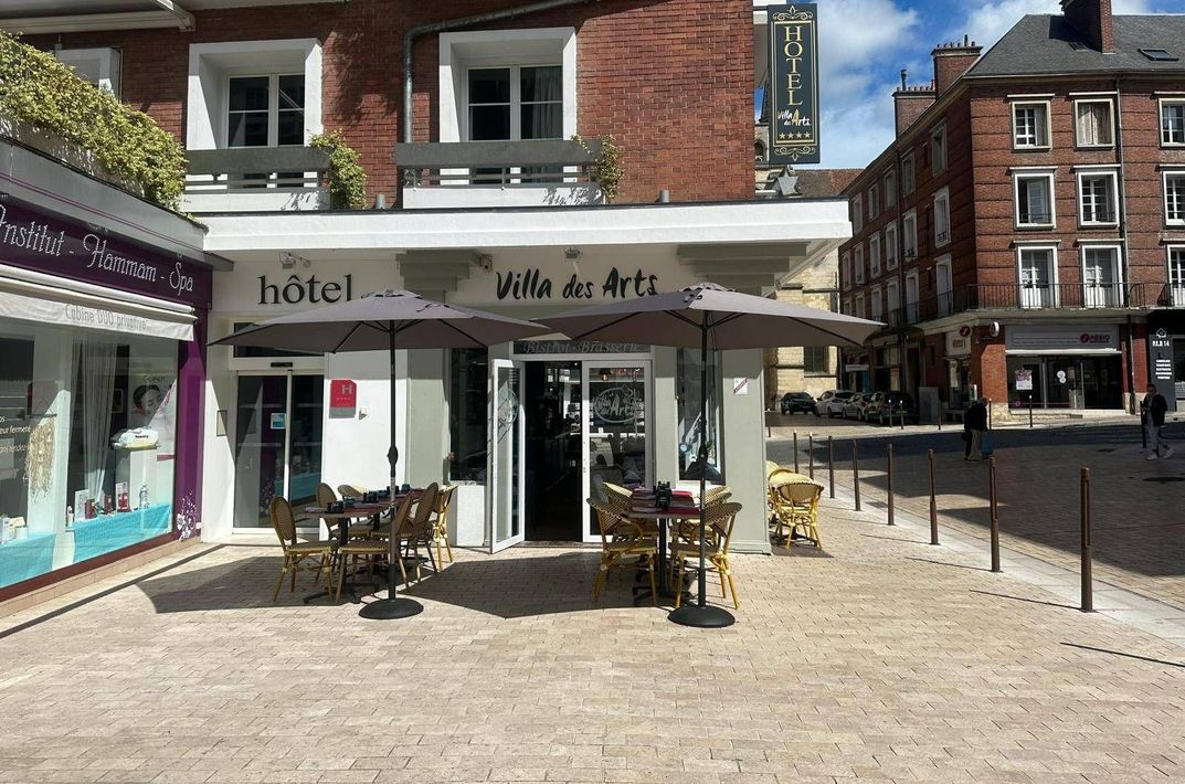 Devanture de l'établissement avec tables en terrasse