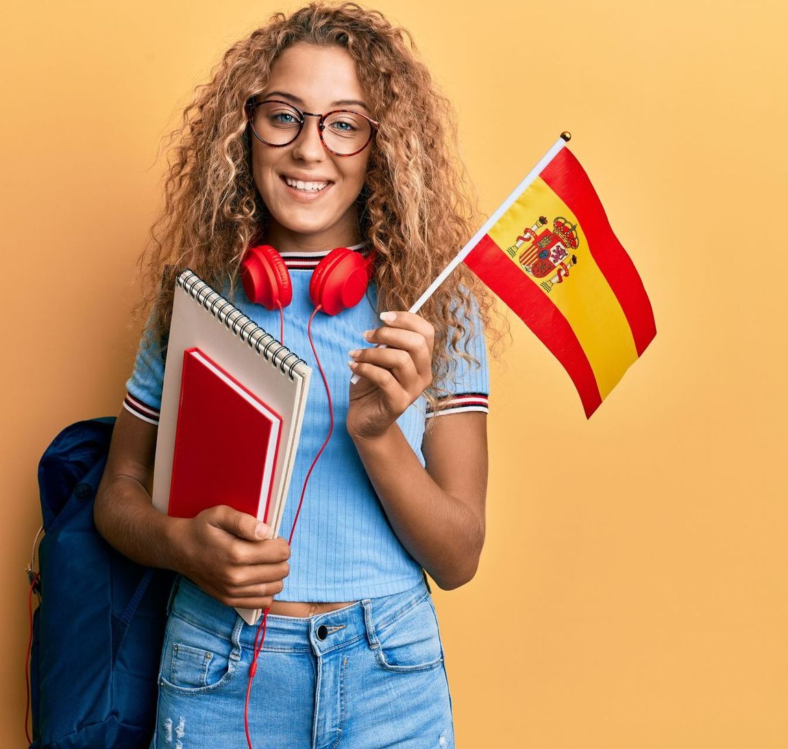 Jeune femme tenant des cahiers et un drapeau espagnol