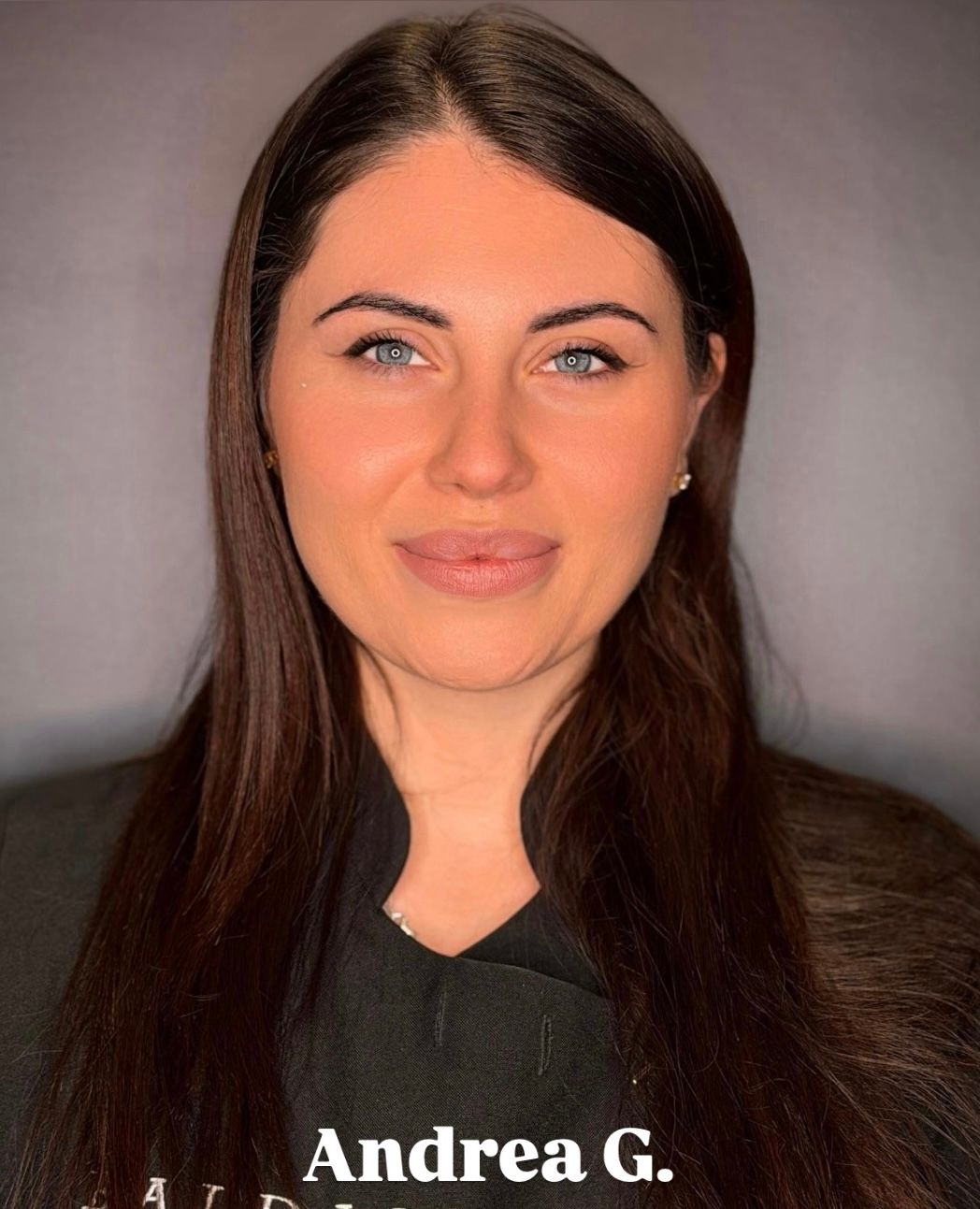 Ritratto professionale di Andrea G. su sfondo grigio, con espressione neutra.