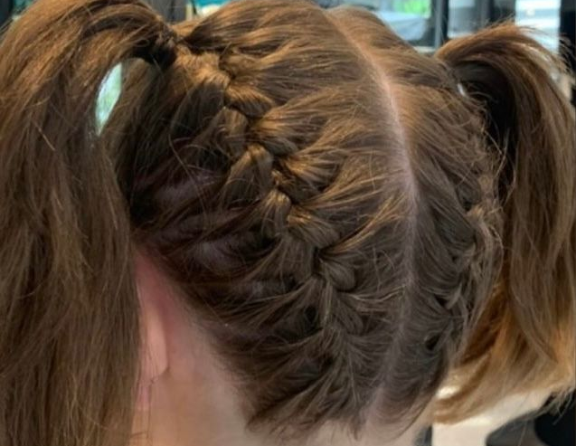 Capelli castano chiaro raccolti in due codini con trecce olandesi che partono dall'attaccatura frontale e arrivano fino alla base della testa.