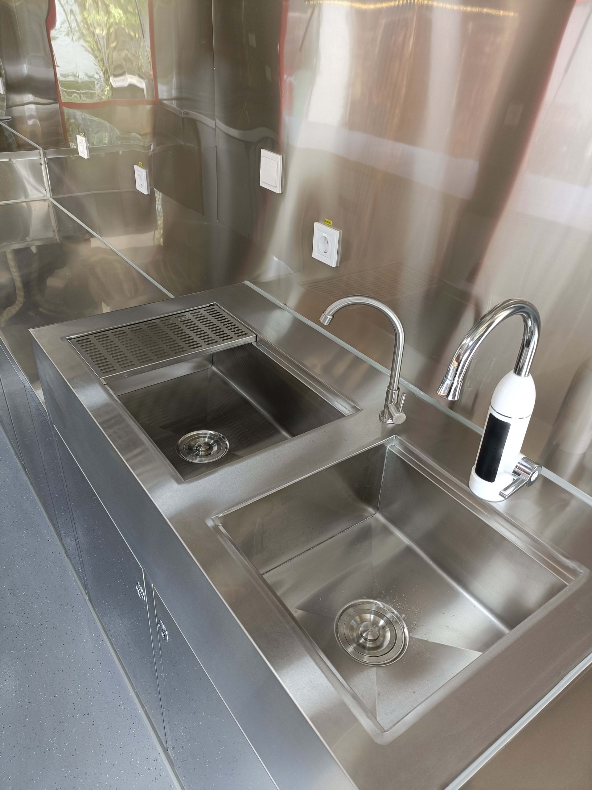 Edelstahlspülen mit Wasserhahn in einem Imbisswagen.