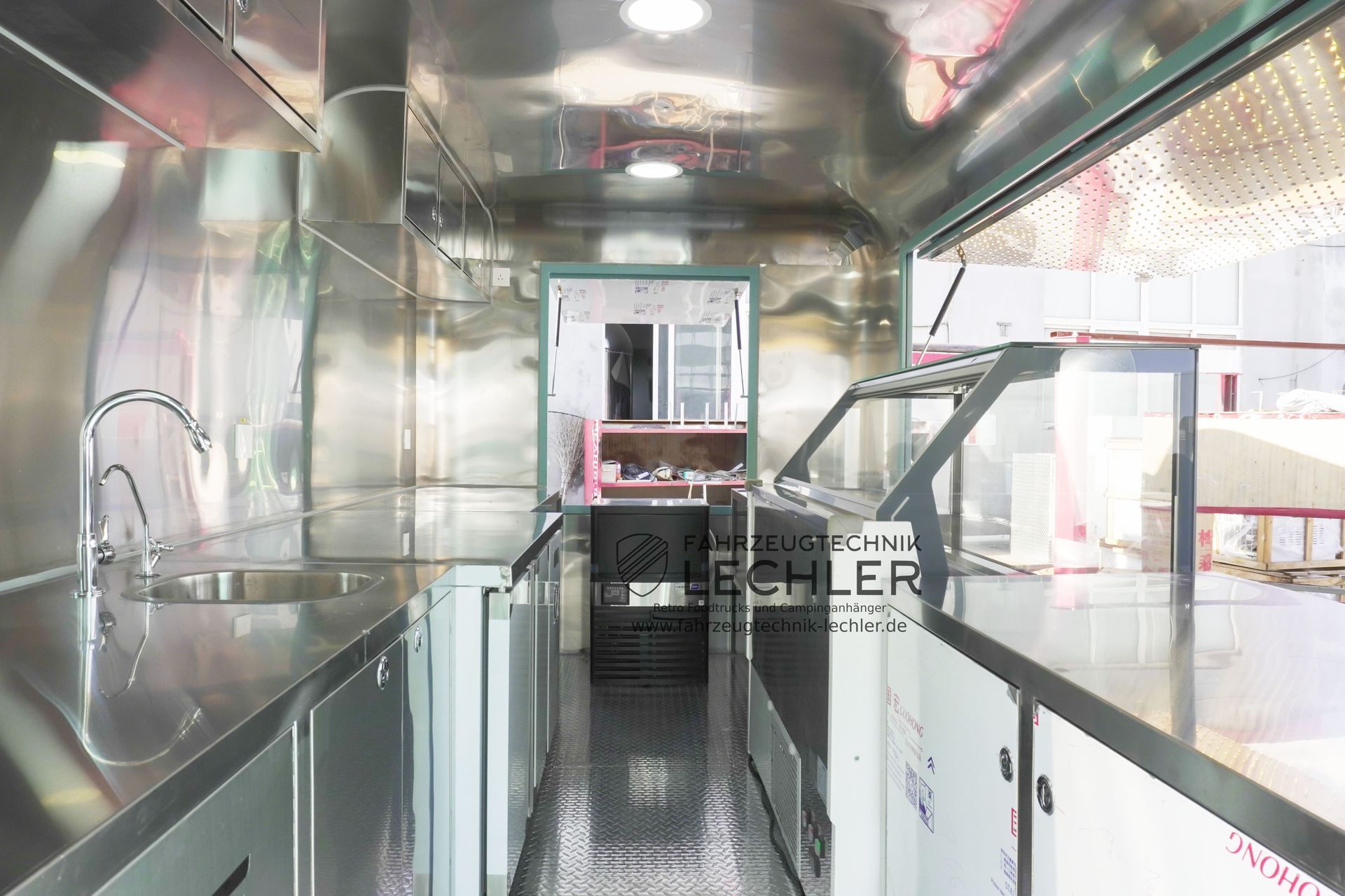 Innenansicht eines Imbisswagens mit Edelstahlflächen, Thekenfläche und Ausgabefenster.