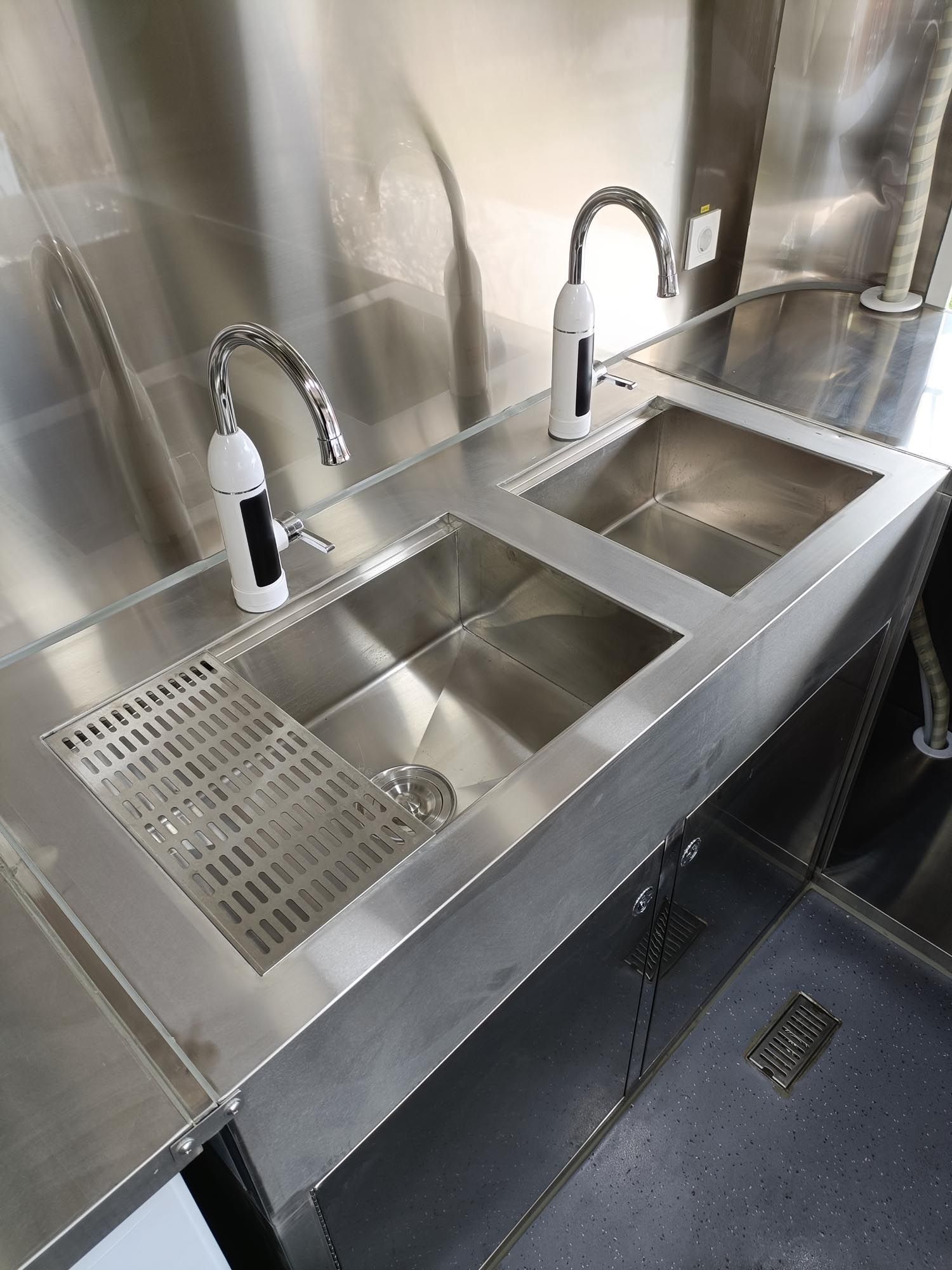 Edelstahlspülen mit Armaturen in einem Imbisswagen.