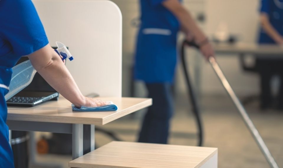 Siivoojat siivoavat toimistoa