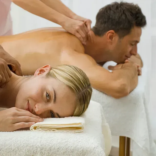 Un hombre y una mujer están recibiendo un masaje en un spa.