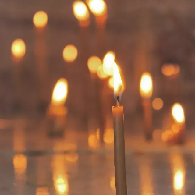 Se enciende una vela delante de un grupo de velas encendidas.