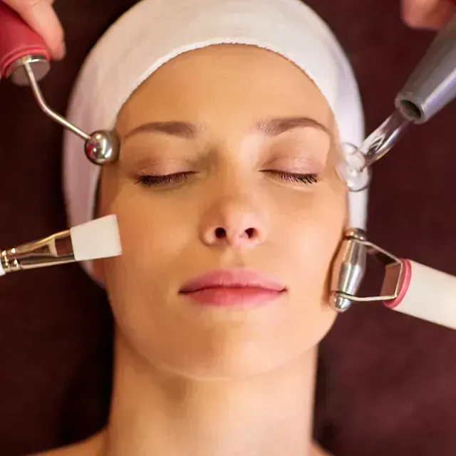 Una mujer con los ojos cerrados está recibiendo un tratamiento facial.