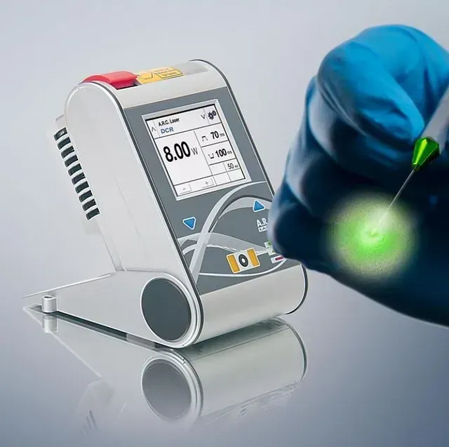 Una mano sostiene un bolígrafo verde delante de una máquina que dice 8.00 en la pantalla.