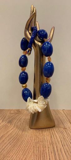 Schmuckhalter-Hand mit Kette aus großen blauen Perlen