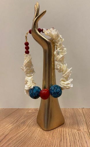 Hand-Schmuckhalter mit Halskette mit großen blauen, roten und weißen Perlen