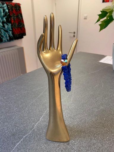 Schmuckhalter in Handform mit Armband aus blauen Steinen