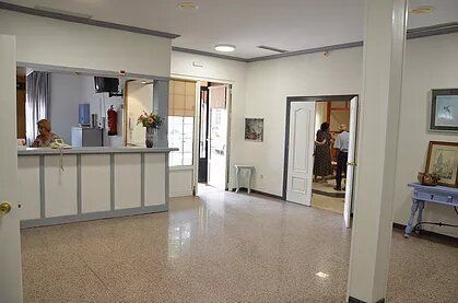 Una mujer está sentada en un mostrador en una habitación grande.