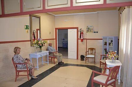 Un hombre y una mujer están sentados en sillas en una sala de espera.