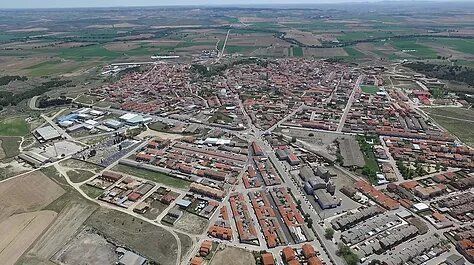 Una vista aérea de un pequeño pueblo rodeado de campos y árboles.