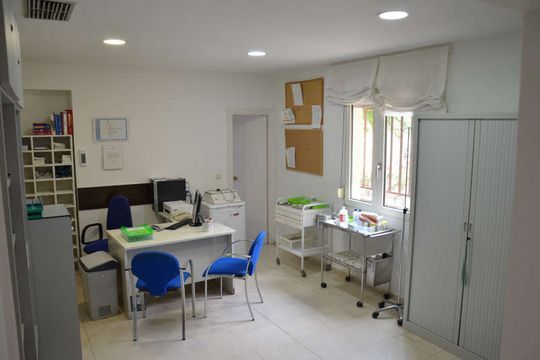 Una habitación con un escritorio y sillas.